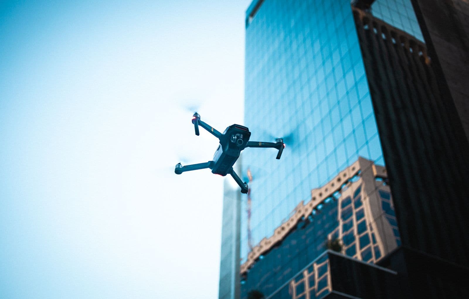 Drone cleaning a high-rise glass facade A cleaning drone flying beside the glass facade of a modern high-rise building